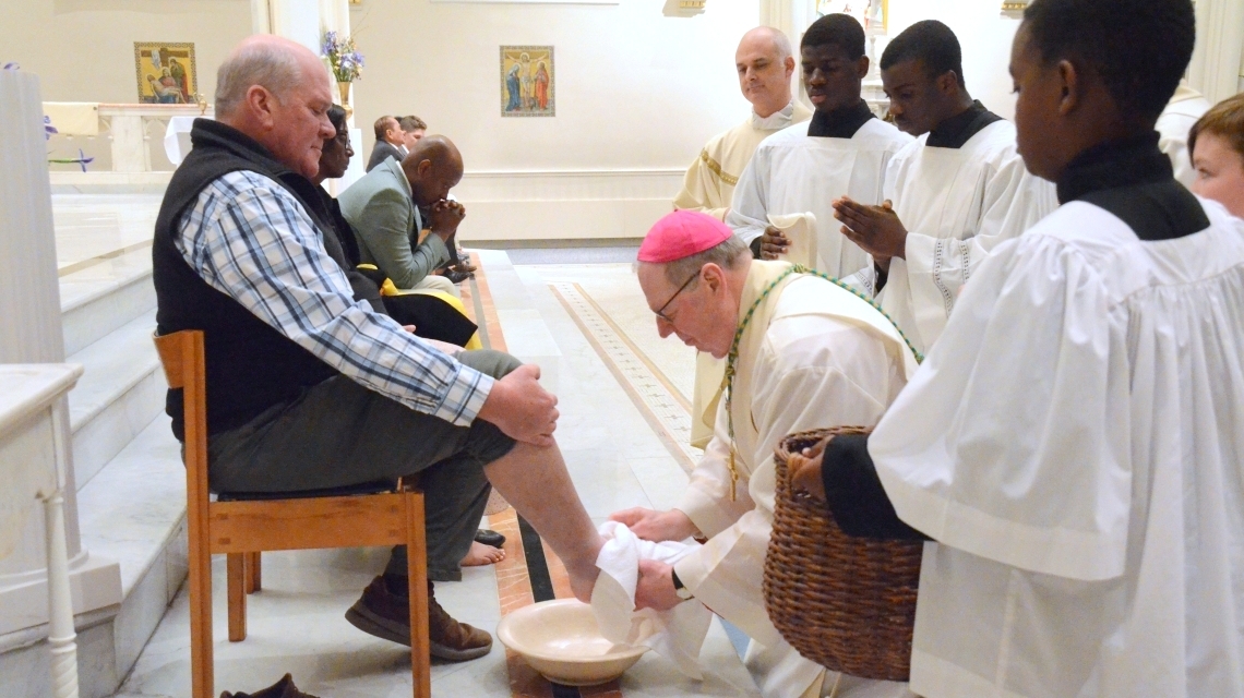 Bishop Deeley washes the feet of a man.