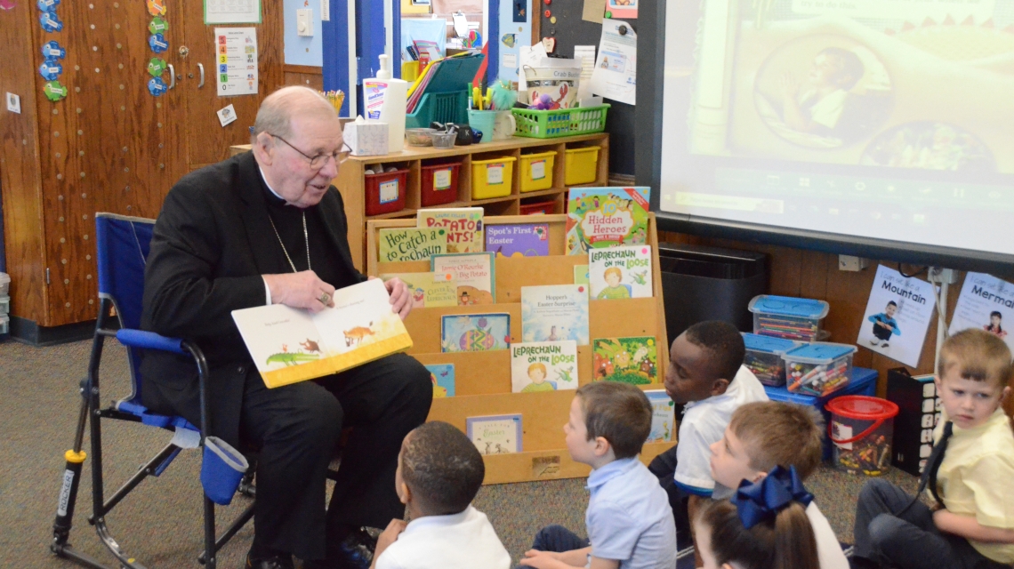 Bishop reading book to students 