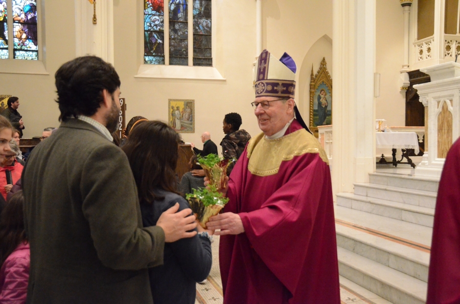 Bishop Deeley handing out pots of clovers to parishoners