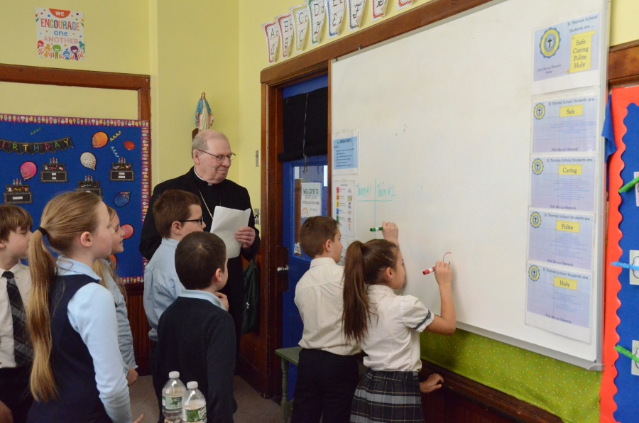 Bishop watching students write on whiteboard