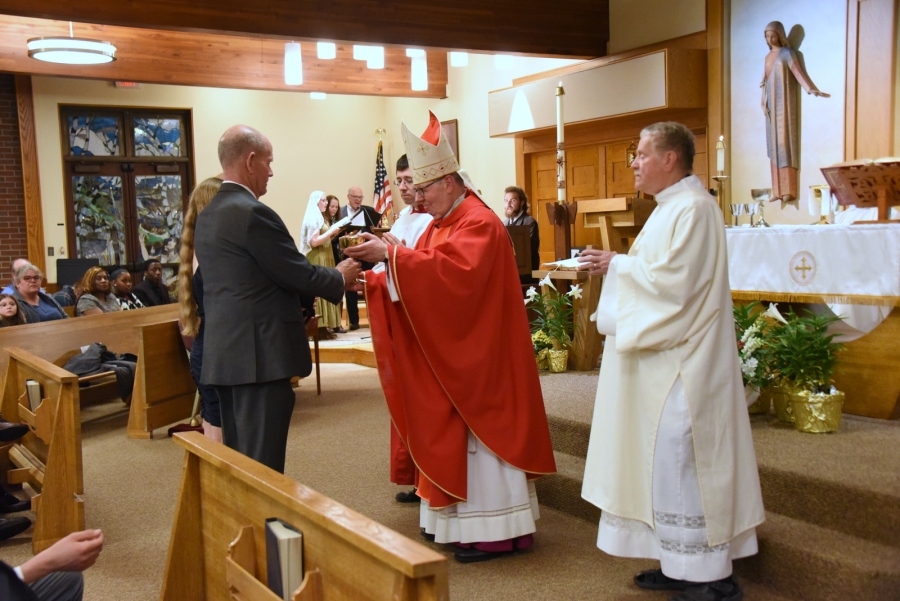 Bishop Deeley accepts the offertory gifts.