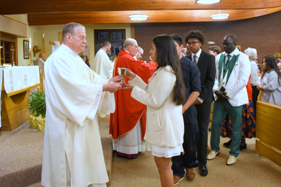 Deacon Dennis Popadak presents to the chalice during holy Communion to one of the newly confirmed.