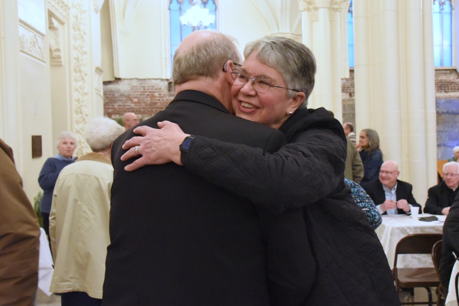 Bishop Deeley receives a hug from a woman.
