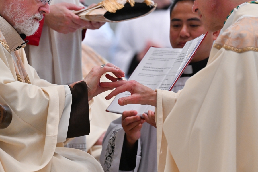 Cardinal O'Malley puts the episcopal ring on Bishop Ruggieri's finger.