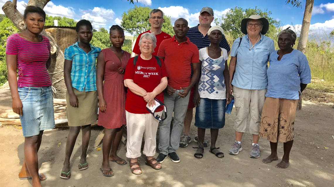 Sister Dale Jarvis, RSM with caseworkers and a family in Haiti.