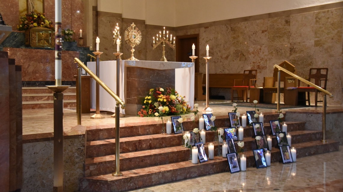Photos of the 18 shooting victims placed on the stairs of Holy Family Church.
