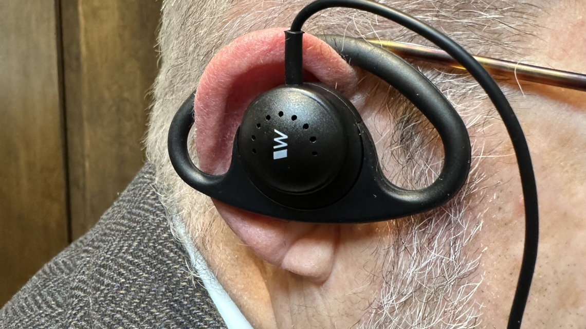 man wearing listening assist device in ear