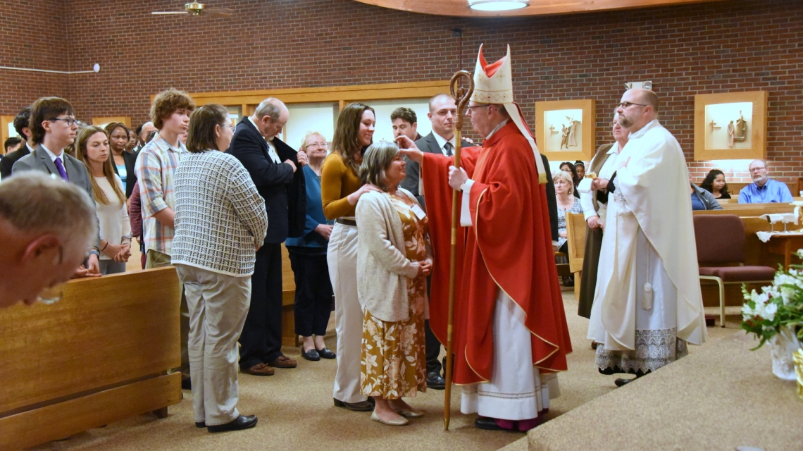 The bishop gives the sacrament of confirmation to a person.