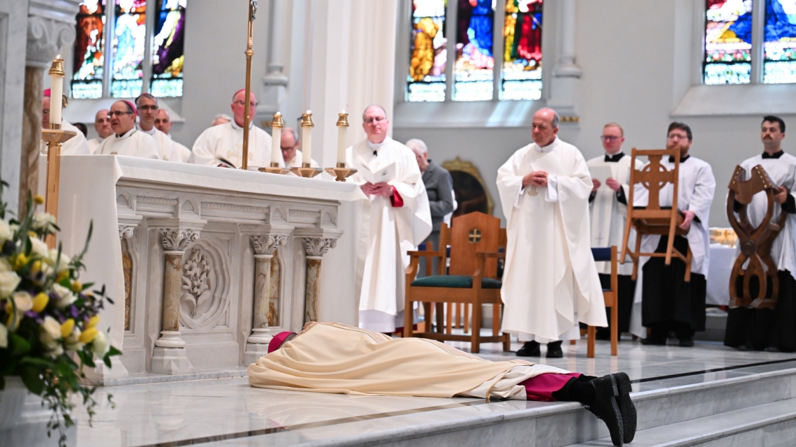 Bishop Ruggieri lies prostrate before the altar.