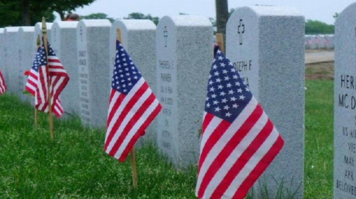 american flags in front of gravestones