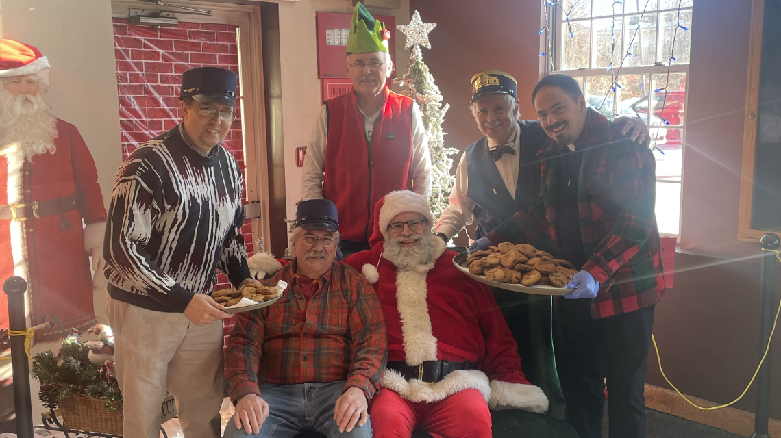 Group surrounding a Santa Claus seated