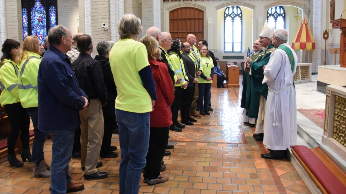 Bishop Ruggieri presents the Matthew 25 Award to a group of volunteers.