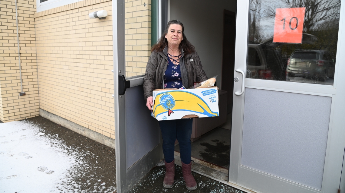 Donna Lathrop carrying a box of food