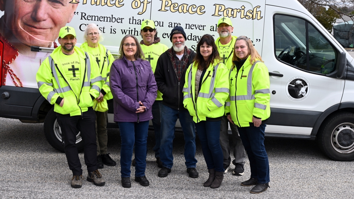 Volunteers with the Cross The Street Ministry standing in front of their food truck