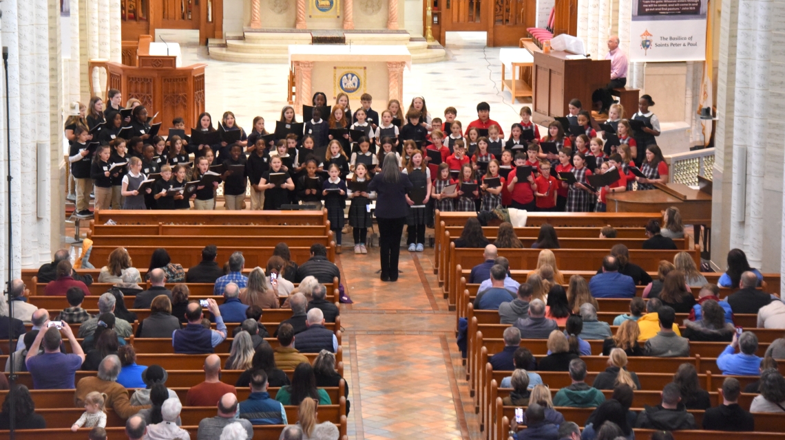 Students singing with people in pews.
