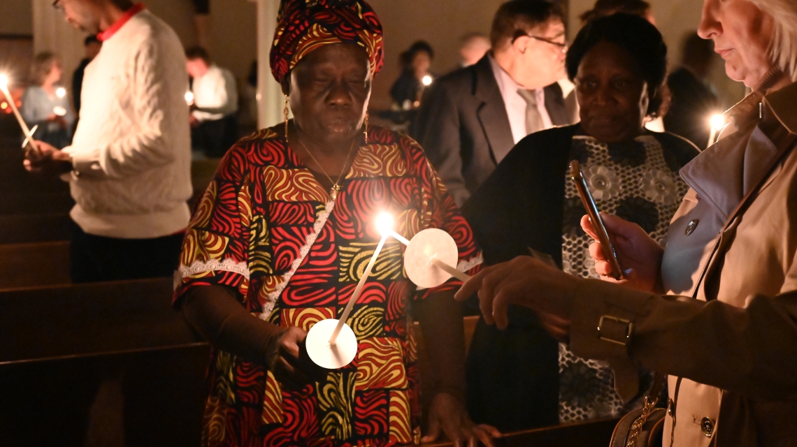 Two members of the congregation light candles
