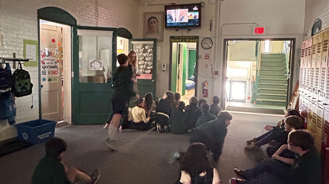 Students at St. John's school gather in front of a tv to watch the Blue Origin Launch