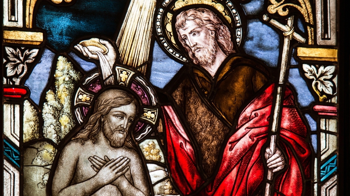 Stained-glass depiction of St. John the Baptist baptizing Jesus.