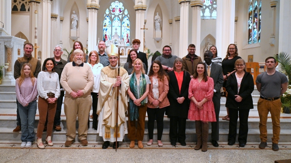Bishop pictured with large group in front of the altar