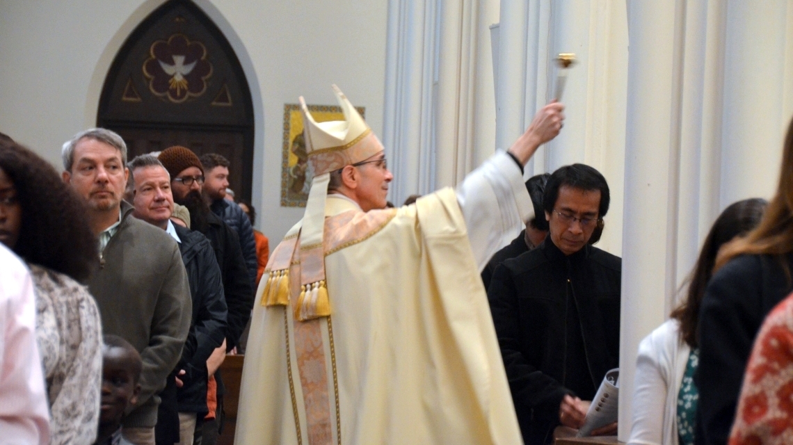 Bishop Ruggieri sprinkles the congregation with holy water.