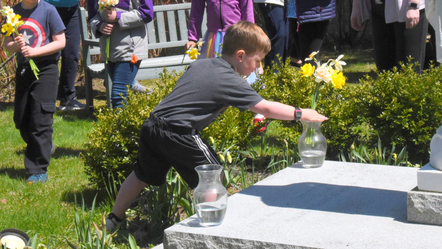 Placing flowers in vases at the foot of a statue of Mary