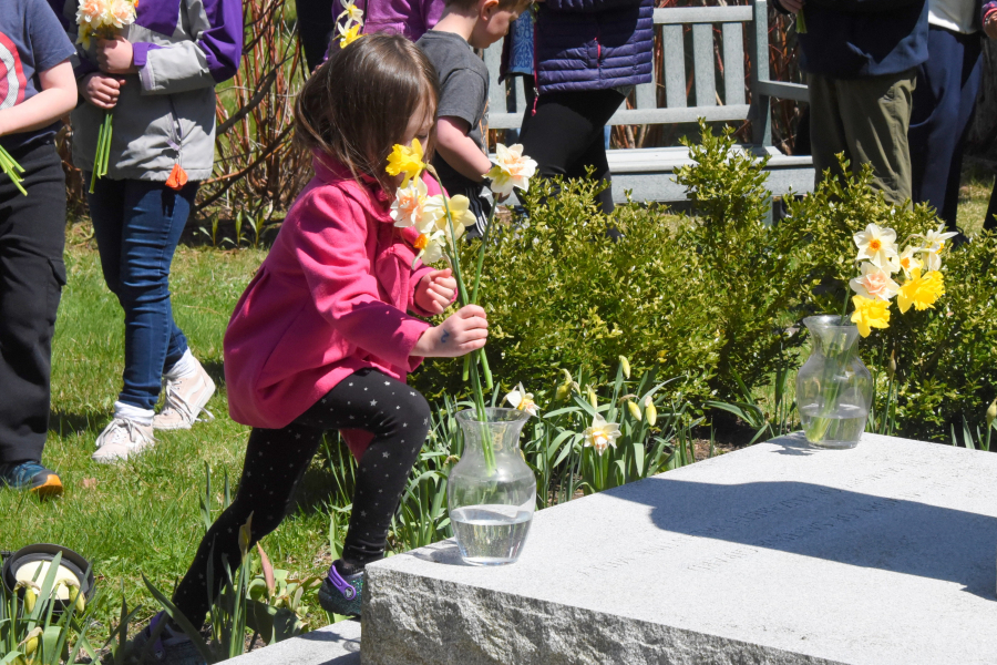 Placing flowers in vases at the foot of a statue of Mary