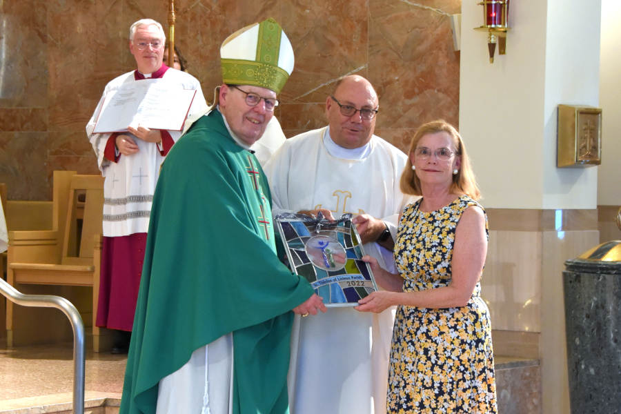 Bishop Deeley presents the award to Father Wilfred Labbe and Barbara Russell.