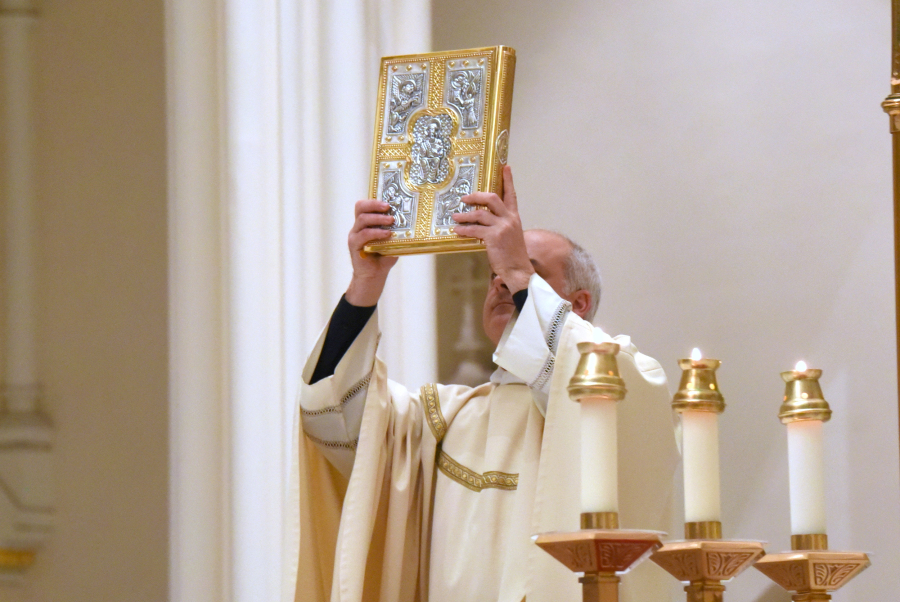 Father Seamus Griesbach with the Book of the Gospels