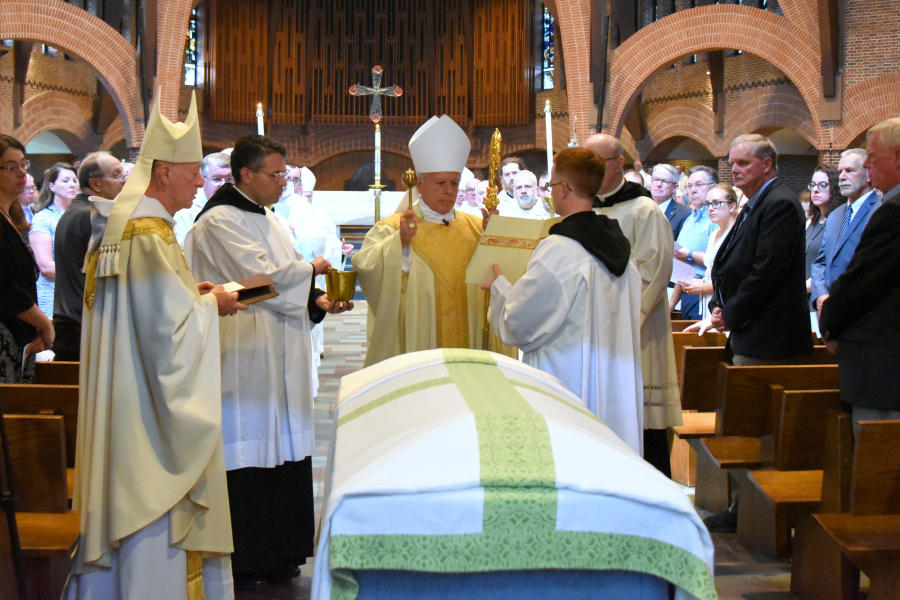 Bishop Libasci prays by the coffin.
