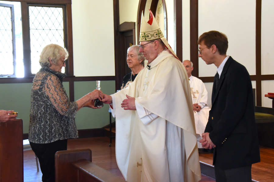 Bishop receives the offertory gifts from Ellin Gallant