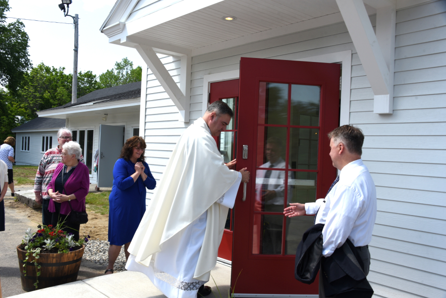 Father Clifford opens the doors to the church.