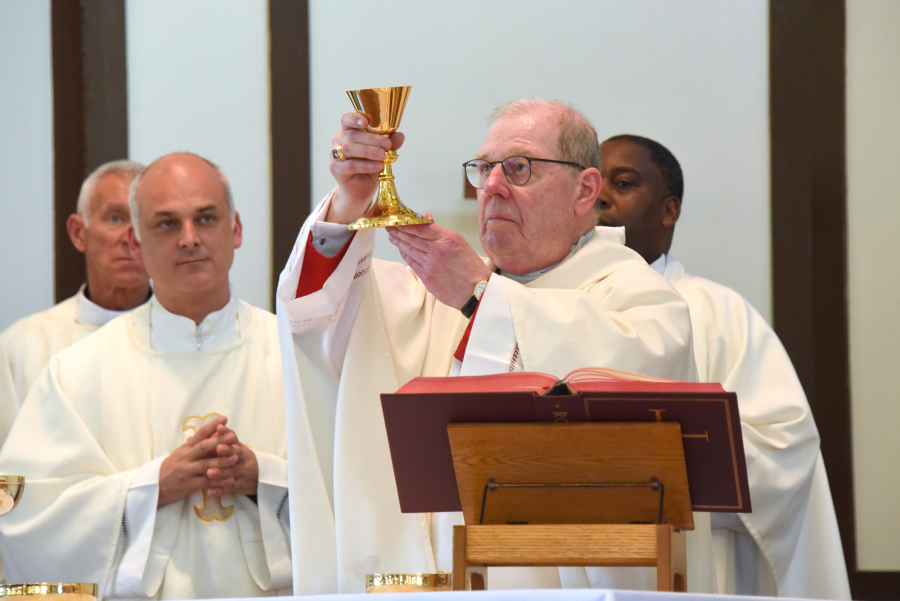 Bishop Robert Deeley holds up the chalice during consecration.