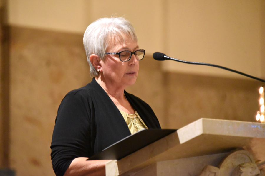 Doris Belanger reads the names of the deceased
