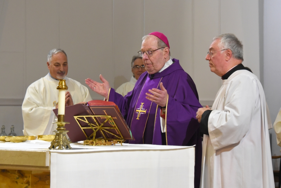 Bishop Robert Deeley at the altar with Msgr Marc Caron to his left.