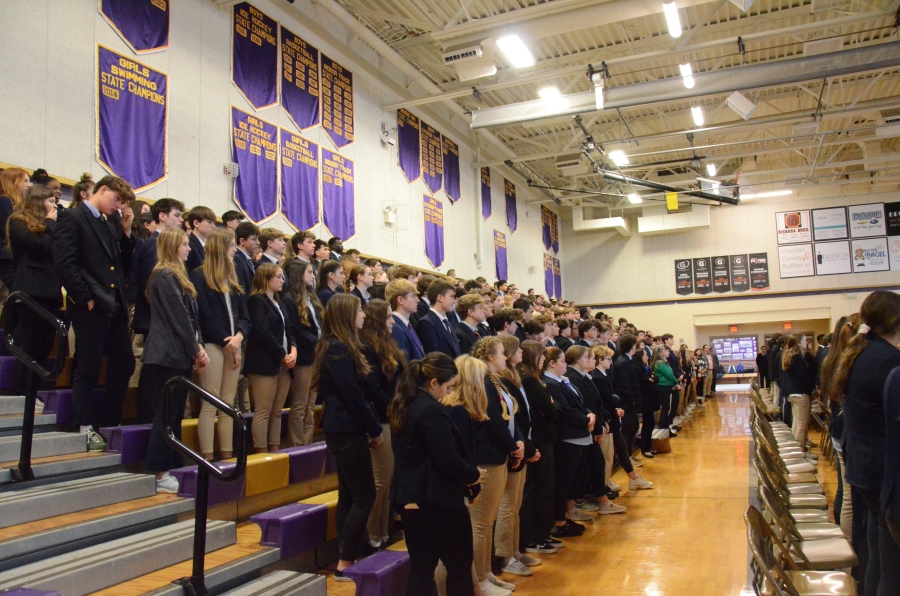 A large group of students standing on gym bleachers