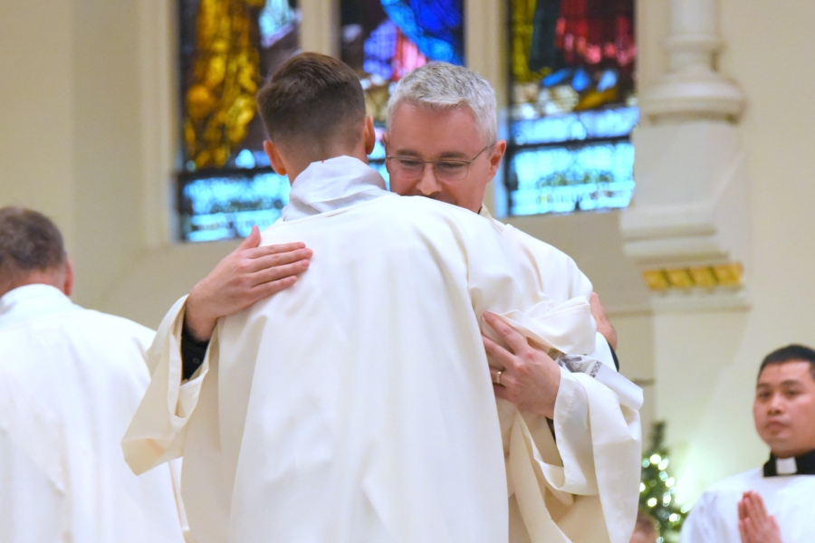 Deacon Luis Sanclemente gives Deacon Matthew Valles the fraternal kiss of peace (a hug)