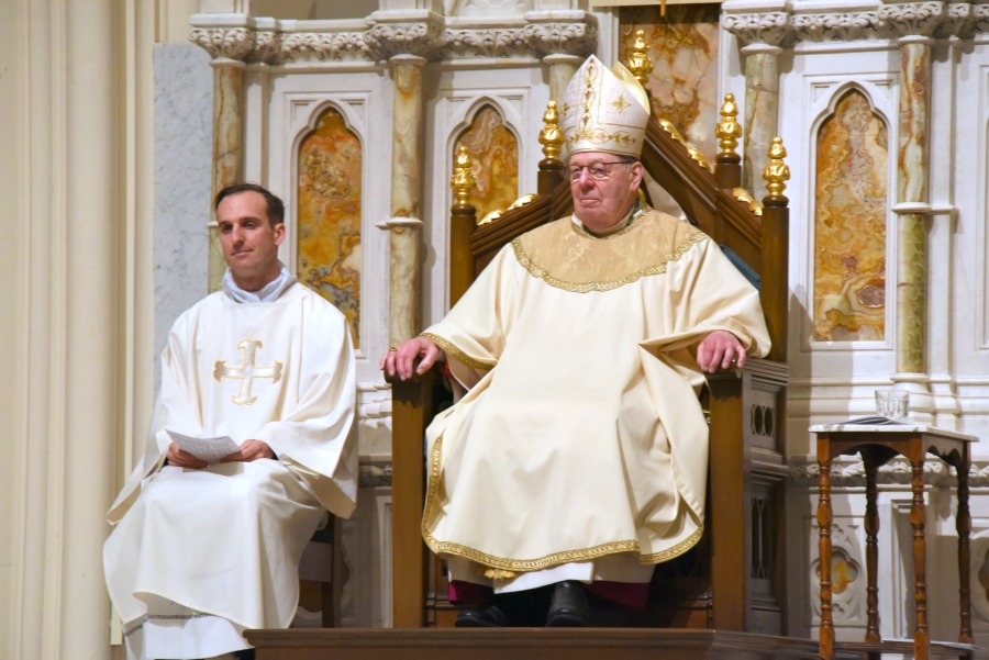 Deacon Matthew Valles sitting beside Bishop Robert Deeley
