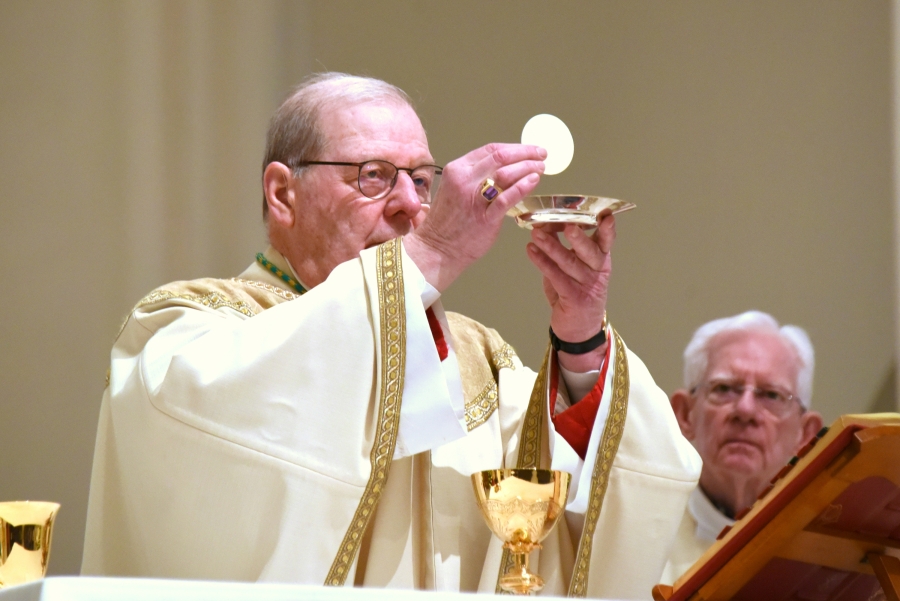 Bishop Robert Deeley holds up the host during consecration.