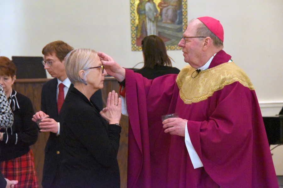 Bishop Deeley marks the forehead of a woman with ashes.