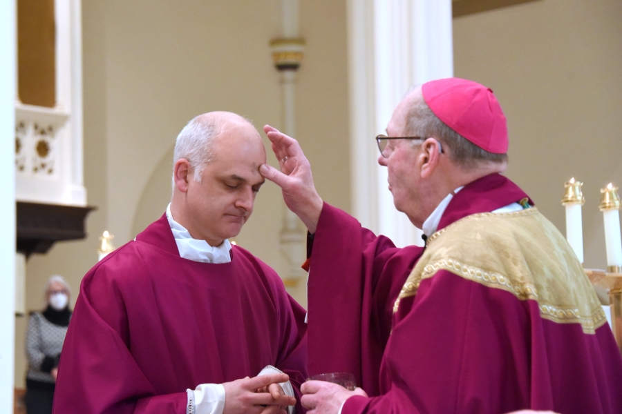 Bishop Deeley anoints the forehead of Father Griesbach with ashes.