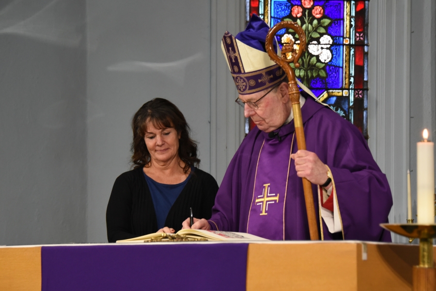 Bishop Deeley signs the Book of the Elect