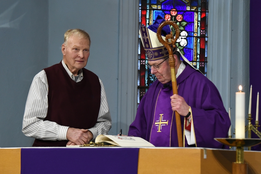 Bishop Deeley signs the Book of the Elect