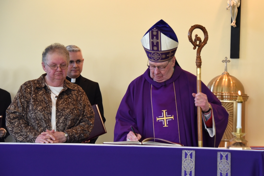 Bishop signing the Book of the Elect with Sister Carol Martin