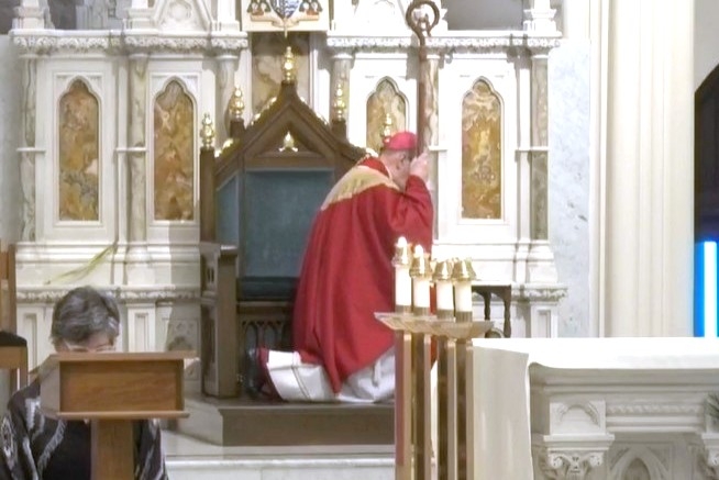 Bishop Robert Deeley kneeling during the Passion.