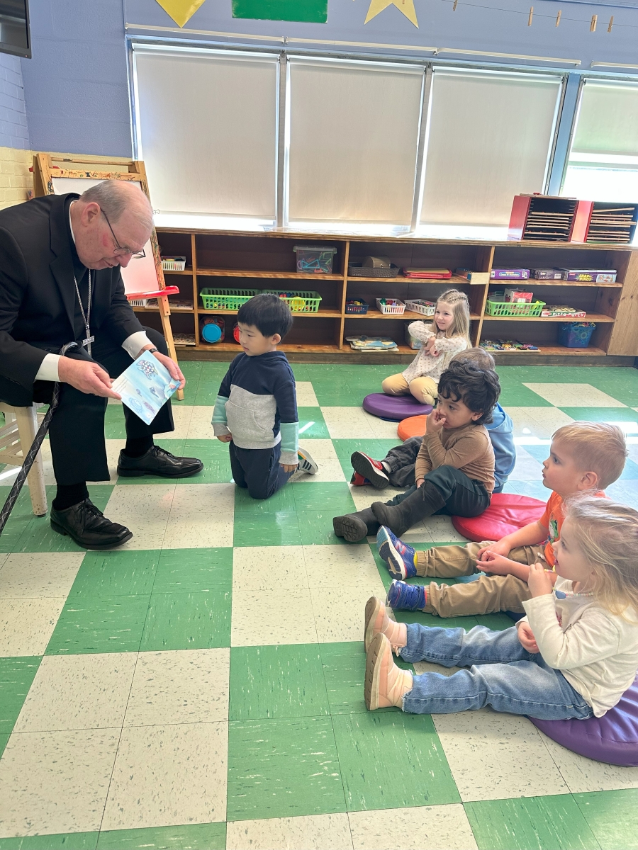 Bishop reading book to students in classroom