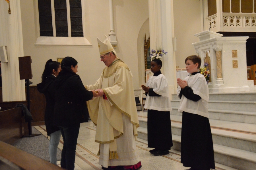 Bishop standing with altar servers
