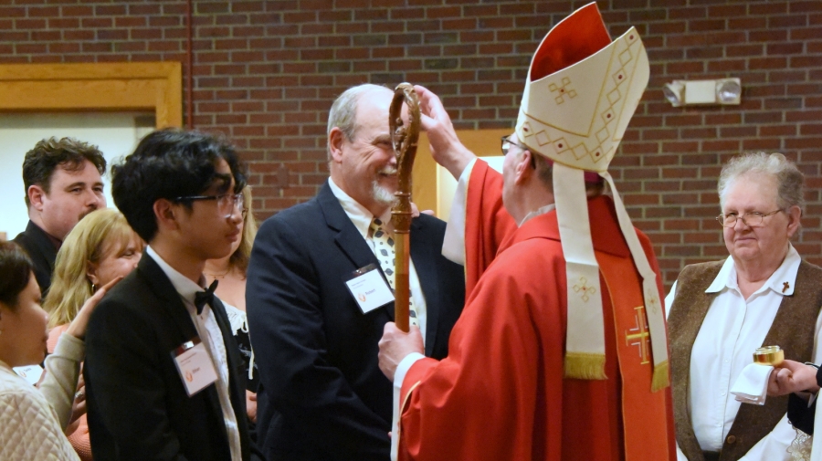 Bishop Deeley offers the sacrament of confirmation to Bob Grinnell.
