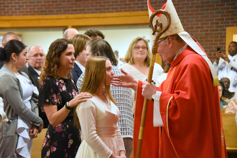 Bishop Deeley offers the sacrament of confirmation to an individual.