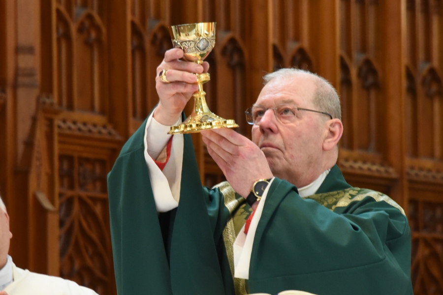 Bishop Deeley holding up the chalice.