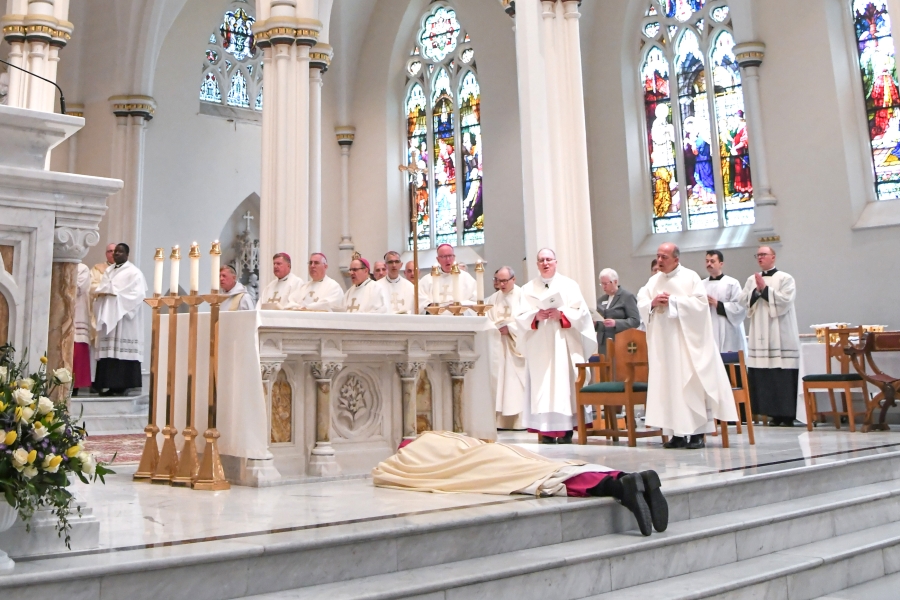 Bishop Ruggieri lies prostrate before the altar.